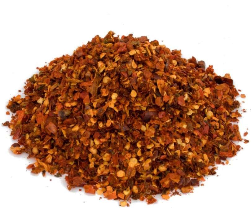 Dried African Bird Eye chilli flakes on a white background